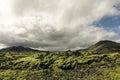 majestic landscape with mountains, moss and cloudy sky